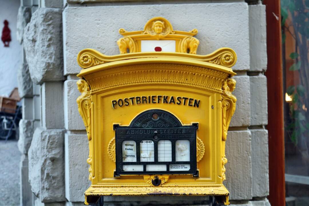 Gelber Postbriefkasten an der Wand als Symbol für ein E-Mail-Abo.